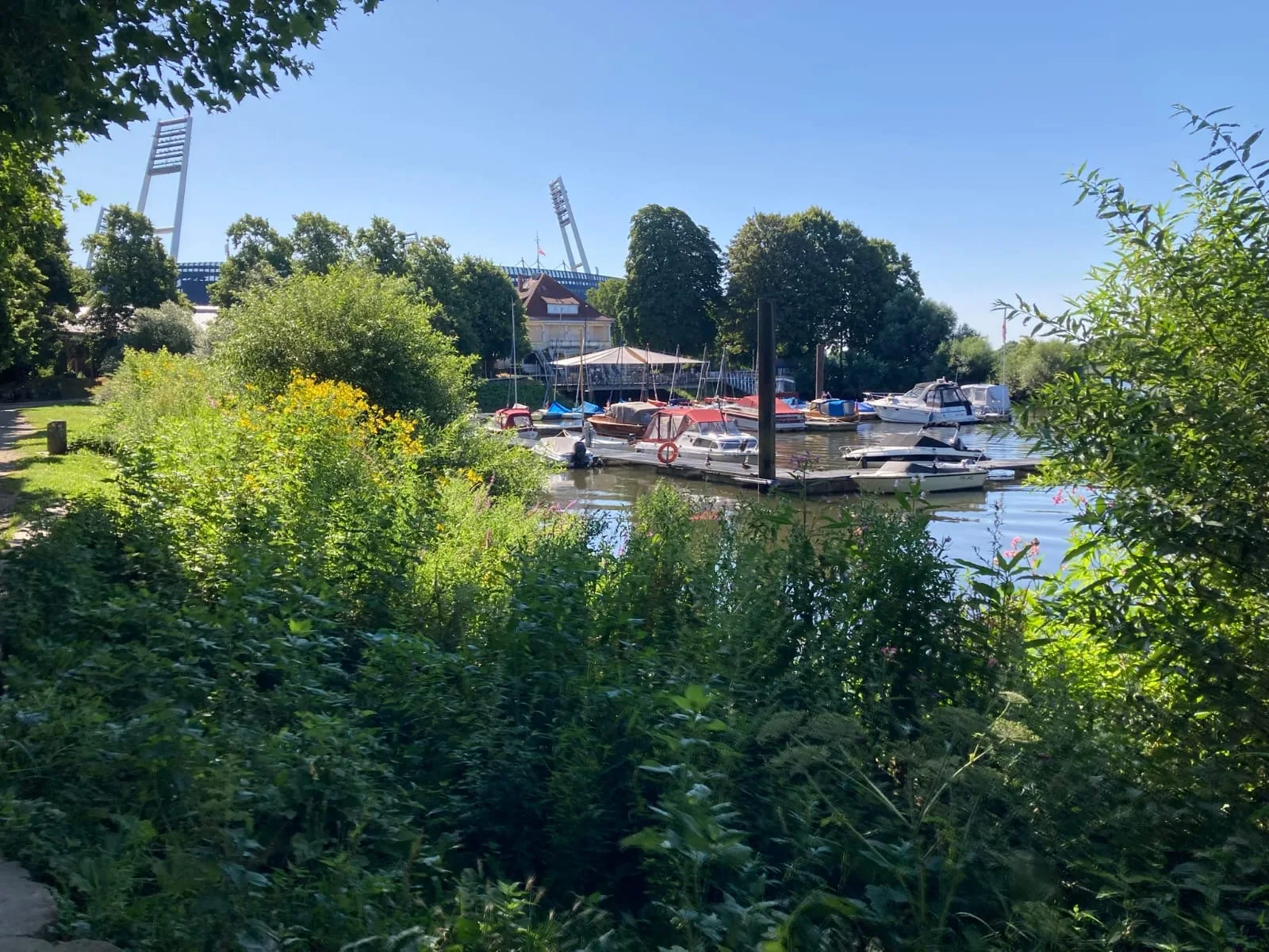 Boote am Wasser, im Hintergrund die Flutlichtmasten des Weserstadions
